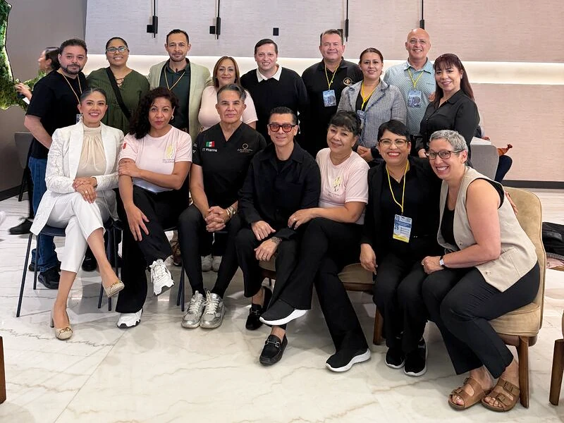 Francisco with a group of event participants, seated and standing together in a meeting room.