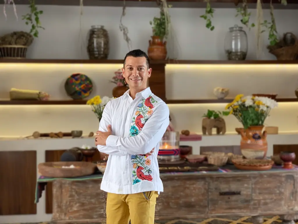 Francisco Lugo in the Chablé Yucatán wellness area, beside a table set with traditional objects and flowers.