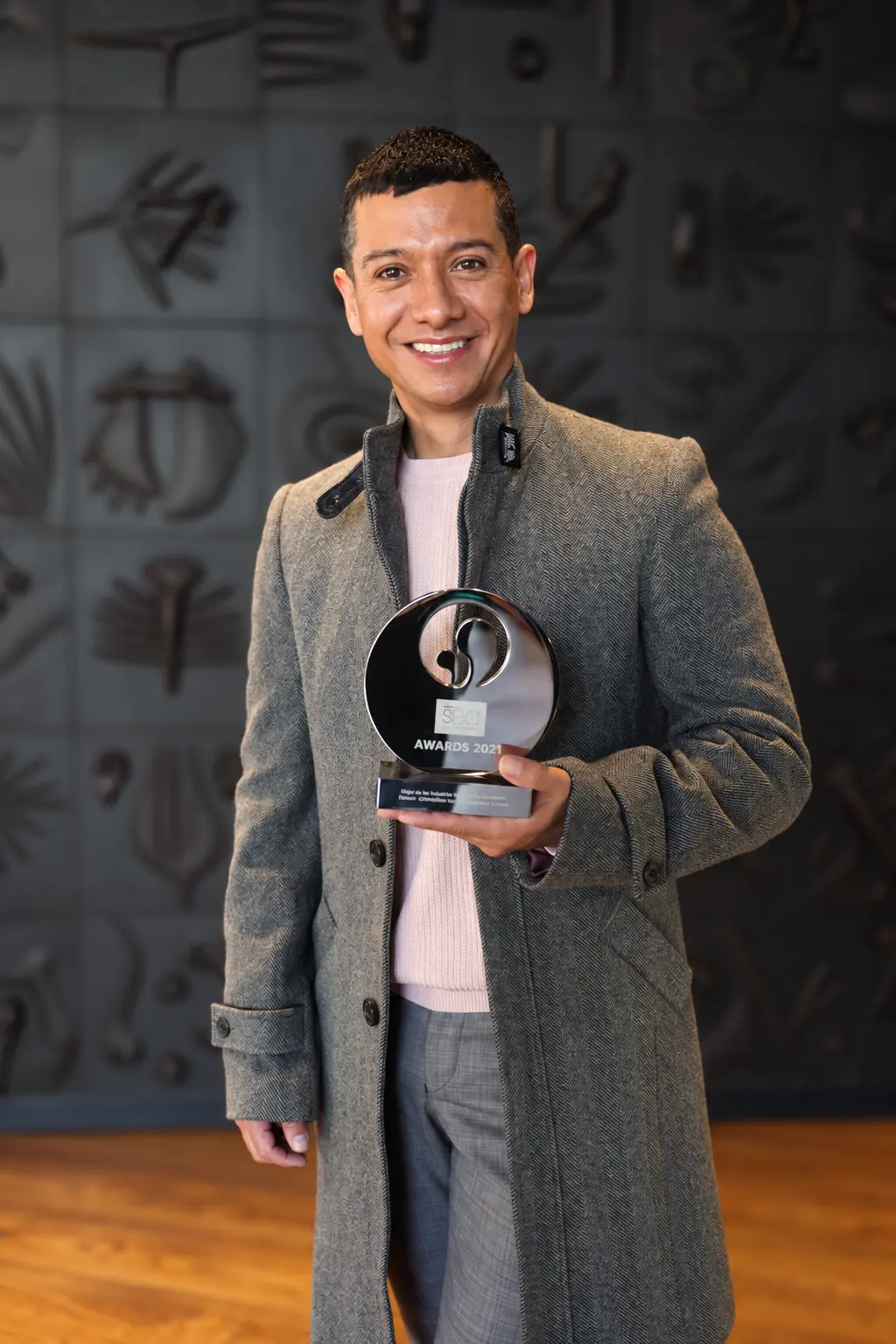 Francisco Lugo holding the Cartesiano wellness award, 2021.
