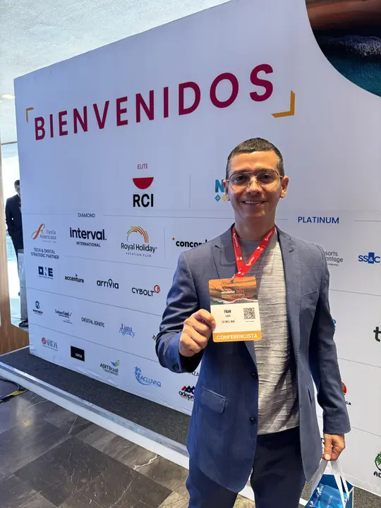 Francisco with his badge at the Congreso AMDETUR 2025 welcome wall.