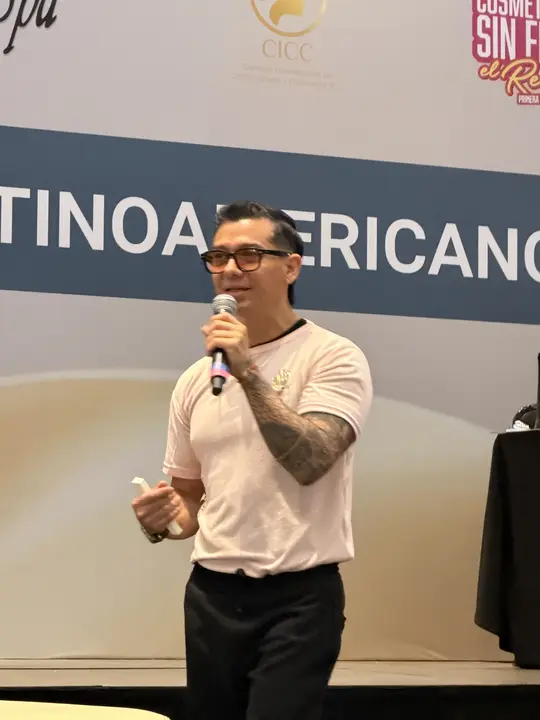 Francisco speaks into a microphone in front of the stage at The Therapist of Today talk.