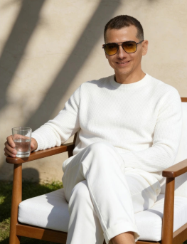 Francisco Lugo seated in a garden, dressed in white
